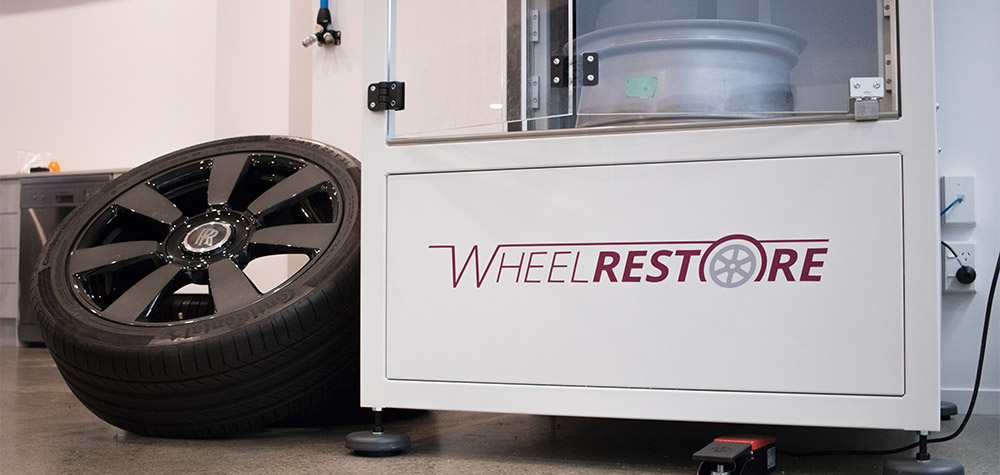 Wheel repair machine with a Rolls Royce wheel next to it